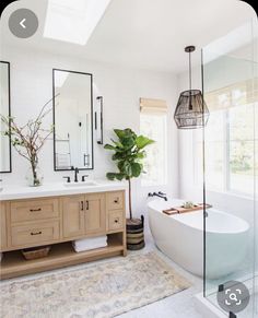 a bathroom with a tub, sink and large mirror on the wall next to it