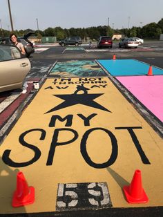 a street sign that says my spot on the side of a road with traffic cones around it