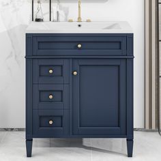 a white sink sitting under a mirror next to a dark blue cabinet with gold knobs