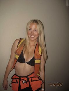 a woman wearing an orange and black construction worker's outfit posing for the camera