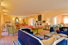 a living room filled with blue couches and chairs next to each other in front of windows