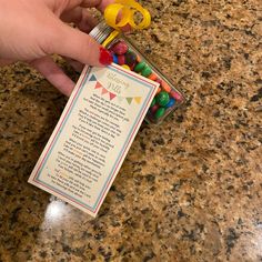 a person is holding some candy in a jar with a poem on the label next to it