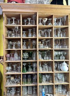 an old wooden cabinet filled with lots of glassware