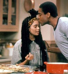 the young man is kissing the woman's forehead in front of the table full of food