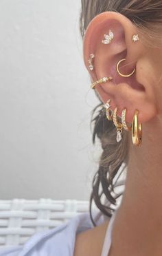 a woman wearing three different types of ear piercings on her left side of the ear