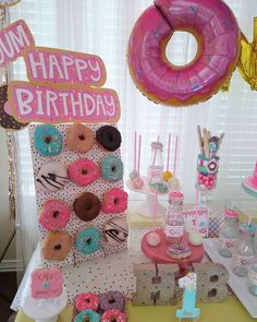 a table topped with lots of donuts covered in frosting and sprinkles