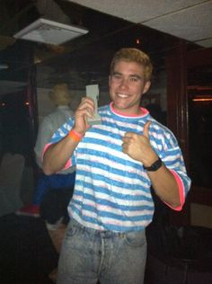 a man in striped shirt holding up a cell phone