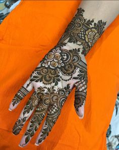 a woman's hand with henna tattoos on it