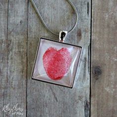 a red heart drawn on a square glass pendant