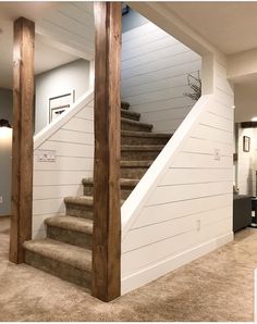 an empty living room with stairs leading up to the second floor