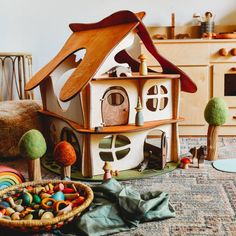 a toy house sitting on top of a rug next to toys and other items in front of it