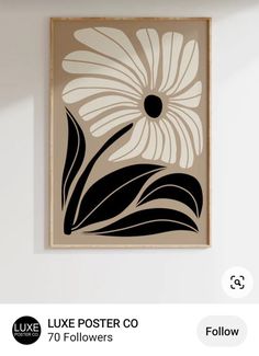 a black and white flower is hanging on the wall next to a framed poster that says,'luxe poster co 70 followerss '