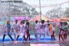 a group of people standing on top of a blue and pink tarp covered field