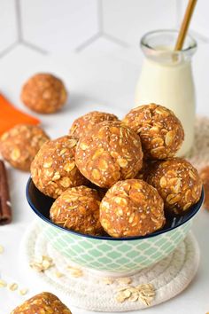 a bowl filled with oatmeal energy bites next to a glass of milk