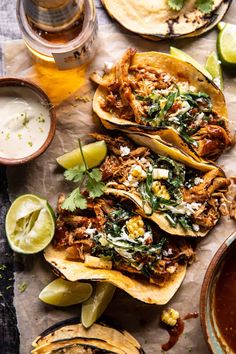 three tacos with shredded meat, cilantro and sour cream