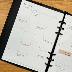 an open planner sitting on top of a wooden table