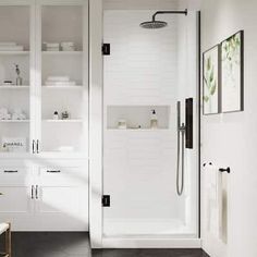 a white bathroom with black and white tile on the floor, shower head, sink, and shelving