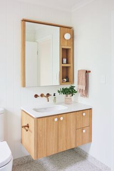 a bathroom with a sink, mirror and wooden cabinet in the corner on the wall