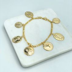 18k Gold Filled Religious Medal Charms Anklet, La Milagrosa, Virgen Guadalupe, El Divino Nino, Dove, "Our Father" Prayer, Wholesale Jewelry Making Supplies.Bracelet Size:-Length: 7 inches | Thickness: 3mmCharms Size:- Guadalupe Virgin Medal: 19mm x 14mm- Medal with Cross: 16mm- Medal with Pigeon: 17mm- Divino Nino Medal: 17mm x 13mm- Saint Benedict Medal: 14mm-Milagrosa Virgin Medal : 19mm x 14mm-Our Father Medal: 13mm Virgin Mary Bracelet Gold, Spiritual Our Lady Of Guadalupe Jewelry Gift, Gold Our Lady Of Guadalupe Necklace In 14k Gold, Spiritual Yellow Gold Our Lady Of Guadalupe Jewelry, Multicolor Our Lady Of Guadalupe Jewelry Gift, Our Father Prayer, Benedict Medal, Charms Bracelet, Saint Benedict