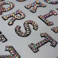 the letters are made up of multicolored glitters and have been placed together