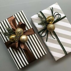 two wrapped presents with gold ornaments on them