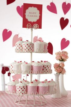 cupcakes are stacked on top of each other in front of pink and red hearts