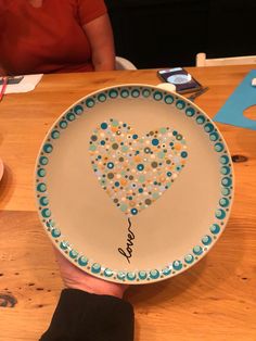 a person holding a plate with a heart on it