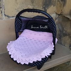 a crocheted pink and black purse sitting on top of a wooden bench next to a stone wall