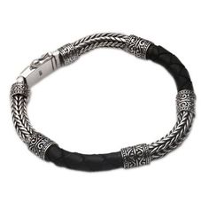 Naga chain of sterling silver is alternated with dark brown braided leather encircling the wrist in this Balinese bracelet. Designed for the modern man the bracelet features a bold design by Cahya Krisna who gives it a regal aesthetic. This accessory closes with a sterling box clasp. Classic Engraved Silver Leather Bracelet, Classic Black Leather Bracelet Engraved, Classic Black Engraved Leather Bracelet, Classic Black Braided Bracelet, Classic Black Engraved Bracelets, Classic Leather Jewelry With Black Band, Modern Engraved Silver Leather Bracelet, Classic Black Bracelets With Oxidized Finish, Black Oxidized Sterling Silver Bracelet