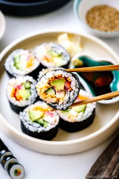 sushi with chopsticks on a white plate