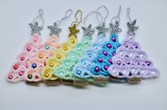 small crocheted keychains are lined up on a white surface with silver sequins