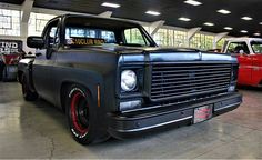 an old black truck parked in a garage