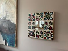 a painting hangs on the wall next to a light switch plate with flowers painted on it