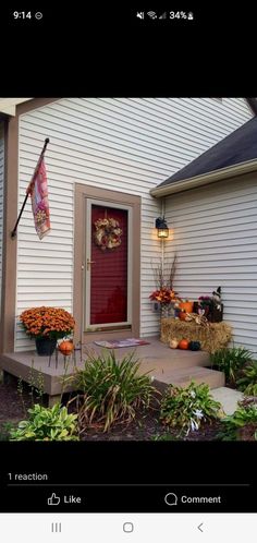 the front porch is decorated with pumpkins, hay bales and flowers for fall