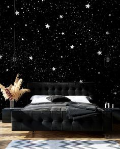 a bedroom with black walls and white stars on the wall