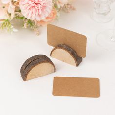 two pieces of wood sitting on top of a table next to some wine glasses and flowers