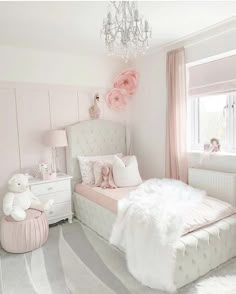 a pink and white girls'bedroom with a chandelier hanging from the ceiling