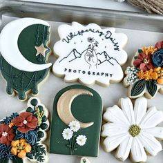 decorated cookies in the shape of flowers and moon are on display at a wedding reception