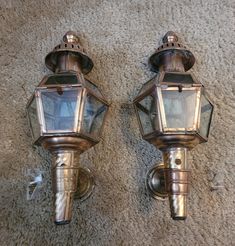 two old fashioned wall lights are on the carpet