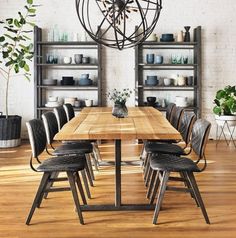 a wooden table surrounded by black chairs in a room with white walls and wood flooring