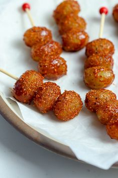 several skewered meatballs on a plate with toothpicks sticking out of them