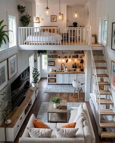 a living room filled with furniture and a fire place next to a staircase leading up to a loft