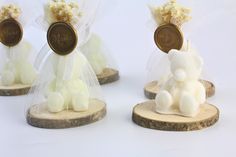 three small figurines made out of wood and white fabric with flowers on them