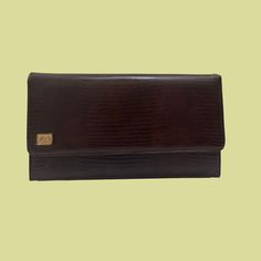 "Vintage Ande brown leather clutch bag, manufactured ca. 1970s. Rectangular shape with gold toned hardware and an \"LA\" logo on the front left. Bag has a location to connect a strap if interested.    - Brand: Ande    - Measurements: 10.5\" x 2.5\" x 6\"\"     - Time Period: 1970s    - Color(s): Brown leather (unsure if faux or real)    - Condition: The bag is in excellent condition with just a bit of wear on the internal lining (see final photo).  This item has 100% FREE United States domestic Vintage Rectangular Business Wallet, Vintage Brown Rectangular Evening Bag, Retro Brown Wallet For Formal Occasions, Classic Brown Evening Bag For Formal Occasions, Classic Brown Formal Evening Bag, Classic Brown Envelope Wallet, Retro Brown Rectangular Clutch, Brown Envelope Bag For Evening, Luxury Brown Envelope Clutch