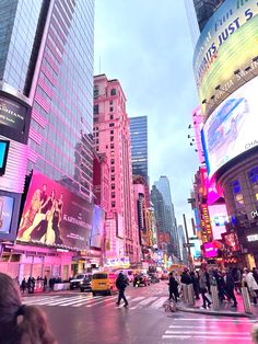 people crossing the street in times square at dusk