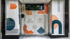 an open door to a building with colorful designs on it's glass panels and doors