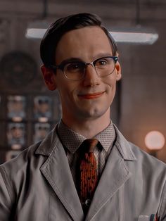 a man wearing glasses and a trench coat with an orange tie in front of him