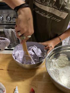 a person mixing something in a bowl with a wooden spoon