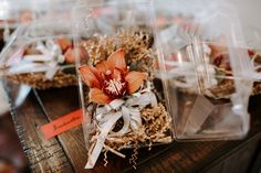 two plastic containers filled with flowers on top of a wooden table next to each other