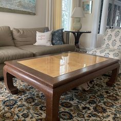 a living room filled with furniture and a dog sitting in front of the coffee table